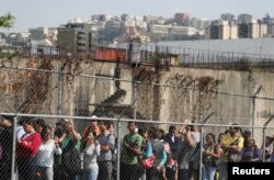 People wait to get on a bus during a blackout in Caracas, Venezuela, March 25, 2019.