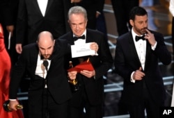FILE - Jordan Horowitz shows the envelope revealing "Moonlight" as the true winner of best picture at the Oscars, Feb. 26, 2017, at the Dolby Theatre in Los Angeles.