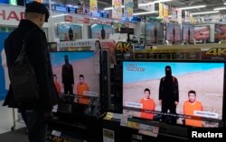 FILE - A man watches a news program about an Islamic State video purporting to show two Japanese captives at an electronics store in Tokyo, January 20, 2015.