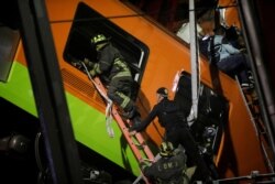 Rescuers work at a site where an overpass for a metro partially collapsed with train cars on it at Olivos station in Mexico City, Mexico May 3, 2021. REUTERS/Luis Cortes