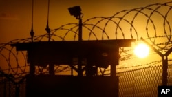FILE - The sun rises above the Camp Delta detention facility at Guantanamo Bay Naval Base, Cuba. The U.S.-run prison currently houses 107 suspected terrorists.