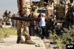 FILE - Iraqi government forces drive down a road leading to Tal Afar, June 9, 2017, during ongoing battles to retake the city from Islamic State fighters.