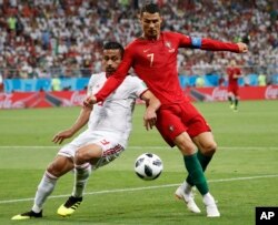 Portugal's Cristiano Ronaldo, right, and Iran's Omid Ebrahimi challenge for the ball during the group B match between Iran and Portugal at the 2018 soccer World Cup at the Mordovia Arena in Saransk, Russia, June 25, 2018.