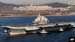 Chinese aircraft carrier Liaoning cruises back to port after its first navy sea trial in Dalian, northeastern China, Oct. 30, 2012.
