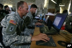 FILE - U.S. soldiers monitor battlefield conditions at a joint U.S.-Afghan command center in Ghazni province, west of Kabul, Afghanistan, June 21, 2007.