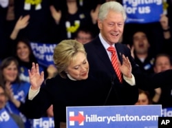 Democratic presidential candidate Hillary Clinton reacts as former President Bill Clinton smiles at her New Hampshire presidential primary campaign rally in Hooksett, New Hampshire, Feb. 9, 2016.