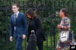 FILE - Kim Kardashian, center, arrives with her attorney Shawn Chapman Holley at the security entrance of the White House in Washington, May 30, 2018.