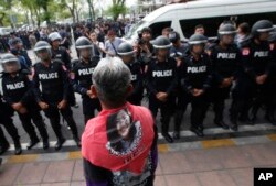 FILE - A Thai pro-democracy protester wears a scarf with a portrait of former Prime Minister Yingluck Shinawatra during a gathering to mark the fourth anniversary of the military takeover of government in Bangkok, Thailand, May 22, 2018.