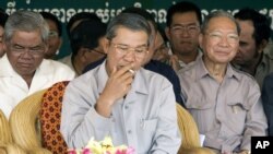 Cambodia's Prime Minister Hun Sen, center, smokes as he sits with Interior Minister Sar Kheng, left, and Finance Minister Keat Chhun, right, file photo.
