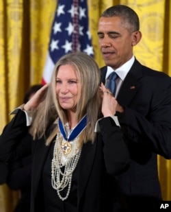 Presiden AS Barack Obama mengalungkan penghargaan Medal of Freedom kepada Barbra Streisand.