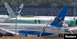 FILE - Workers on lifts are pictured near the tail of a Boeing 787-8 Dreamliner being built for for Xiamen Airlines.