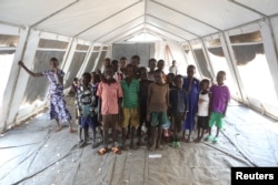 FILE - Children, who fled fighting in South Sudan, stand inside a tented classroom at the Bidi Bidi refugee resettlement camp near the border with South Sudan, in northern Uganda, Dec. 7, 2016.