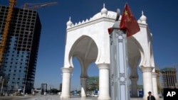 FILE - A man walks past a pavilion with Islamic architectural features in Yinchuan in northwestern China's Ningxia Hui autonomous region, Oct. 8, 2015.