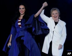 Katy Perry holds hands with Democratic presidential nominee Hillary Clinton during a concert at the Mann Center for the Performing Arts, Nov. 5, 2016, in Philadelphia.