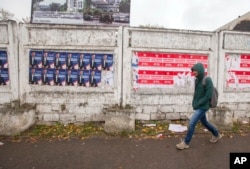 A woman walks by electoral posters in Chisinau, Moldova, Oct. 26, 2016. Moldovans will vote for a president Sunday for the first time in 20 years in an election which could move the former Soviet republic closer to Europe or rekindle the nation's old ties