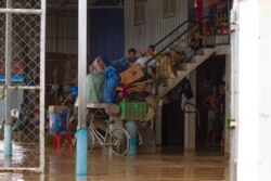 កុមារមួយក្រុមអង្គុយលើជណ្តើរផ្ទះដែលត្រូវបានទឹកជន់លិច នៅសង្កាត់ស្ពានថ្ម ខណ្ឌដង្កោរ ភ្នំពេញ ថ្ងៃទី១៤ ខែតុលា ឆ្នាំ២០២០។ (ទុំ ម្លិះ/វីអូអេ)