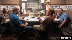 People talk during a show at the WAPA 680 radio station, in San Juan, Puerto Rico, Sept. 27, 2017.