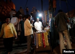 A man lights a cigarette at a roadside stall in the old quarters of Delhi, India, May 30, 2017.