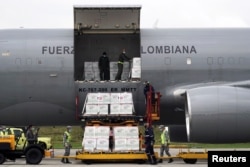 FILE - A shipment of Johnson & Johnson vaccines against the coronavirus disease, donated by the U.S., is unloaded in Bogota, Colombia, July 1, 2021. (REUTERS/Nathalia Angarita)