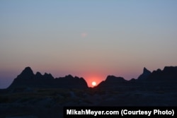 The setting sun casts a magical glow over the rocks of the Badlands.