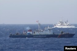 A ship (top) of Chinese Coast Guard is seen near a ship of Vietnam Marine Guard in the South China Sea, about 210 km (130 miles) off shore of Vietnam May 14, 2014.