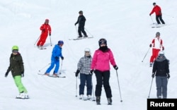 FILE - Chinese ski instructor Xu Zhongxing (2nd L) skis on the Lauberhorn in the ski resort of the Jungfrau region in Switzerland.