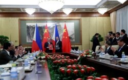 Philippine President Rodrigo Duterte (L) and Chinese President Xi Jinping (R) clap as they attend a signing ceremony at the Diaoyutai State Guesthouse in Beijing, China, August 29, 2019. How Hwee Young/Pool via REUTERS - RC1A6551E6E0