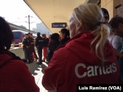 Austrian relief workers await thousands of refugees arriving at the Vienna train station from the Hungarian border, Sept. 6, 2015.
