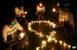 Aktivis memegang lilin pada acara peringatan Hari AIDS Sedunia di Jakarta, Rabu, 1 Desember 2021. (Foto: AP)