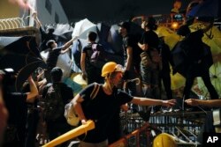 홍콩 경찰본부 앞에서 '범죄인인도조례' 개정안에 반대하는 시위대들이 27일 감시카메라에 스프레이를 뿌리고 있다.