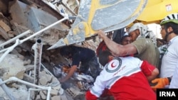 مردم محلی و گروه های امدادی در شهر سرپل ذهاب در حال کمک به افراد زیر آوار مانده،‌ هستند.