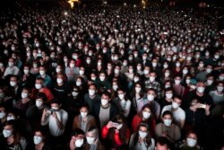People using face masks attend a music concert in Barcelona, Spain, Saturday, March 27, 2021.