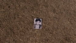 A photo of Najieh dressed as a boy at a young age lies in a grass, in Kabul, Afghanistan, Sunday, Dec. 19, 2021.