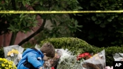 Dečak ostavlja cveće na mestu zločina ispred sinagoge