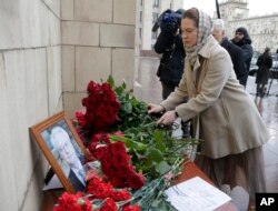 People pay last respect as they put flowers to a portrait of the late Russian Ambassador to the United Nations Vitaly Churkin, outside the Foreign Ministry headquarters in Moscow, Russia, Feb. 21, 2017.