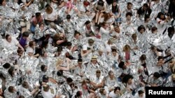 Immigration activists wrapped in silver blankets, symbolising immigrant children that were seen in similar blankets at a U.S.-Mexico border detention facility in Texas, protest inside the Hart Senate Office Building after marching to Capitol Hill in Washington, U.S.