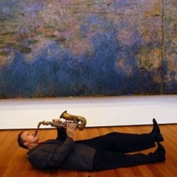 Ted Nash next to a painting by Claude Monet