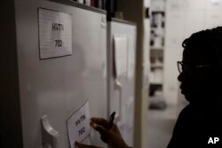 Pharmacist Mary Chindanyika labels a fridge containing a trial vaccine against HIV on the outskirts of Cape Town, South Africa, Nov. 30, 2016. The latest attempt in the long, frustrating search for a vaccine against HIV has begun in South Africa.