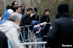 FILE - Migrants wait for their registration in front of the Federal Office for Migration and Refugees at Berlin's Spandau district, Germany, Jan. 29, 2016.