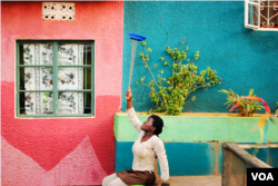 One of the youngest members of the Hiccup Circus practices her plate spinning technique in a quiet corner of the compound in Uganda. (Elizabeth Paulat)