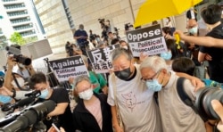 香港天主教教区荣休主教陈日君枢机（右一）到西九龙裁判法院声援8-18案被告，与其中两名被告李卓人及何秀兰打招呼 (美国之音/汤惠芸）