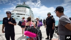 This photo provided by the Dutch Defense Ministry on Sept. 10, 2017, shows people walking toward a cruise ship anchored on St. Maarten, after the passage of Hurricane Irma.