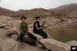 In this July 30, 2018, photo, a 17 year-old boy holds his weapon in High dam in Marib, Yemen. Experts say child soldiers are “the firewood” in the inferno of Yemen’s civil war, trained to fight, kill and die on the front lines. (AP Photo/Nariman El-Mofty)