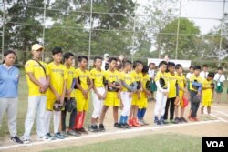 យុវជន​កម្ពុជា​ឈរជា​ជួរ​ដើម្បី​ត្រៀម​ចូល​លេង​កីឡា​បេស្បល​នៅ​ទីលាន​មួយ​ក្នុង​ឃុំបល្ល័ង ភូមិ​ដូងស្រុក​បារាយណ៍ ខេត្ត​កំពង់​ធំកាលពី​ថ្ងៃទី​១៨ មីនា ឆ្នាំ២០១៨។(ទុំ ម្លិះ/VOA)