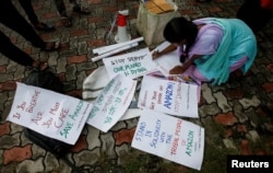 A student writes placards before a protest march demanding protection for the Amazon rainforest near the consulate of Brazil in Kolkata, India, August 26, 2019.