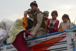 Keluarga pengungsi Afghanistan naik ke truk yang membawa mereka kembali ke negara asal mereka di pusat repatriasi Komisaris Tinggi PBB untuk Pengungsi (UNHCR) di pinggiran Peshawar, 1 Maret 2018. (AFP)