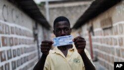 FILE - A man displays a sample 100 franc note in a fictional Ivorian currency, in Abidjan, Ivory Coast, Jan. 8, 2011. Some analysts argue Ivory Coast is among regional countries strong enough to break off on their own.