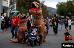 People wearing costumes walk during Halloween in Sierra Madre, California, U.S., October 31, 2017.