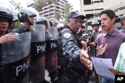 A police officer blocks an opponent to Venezuela's President Nicolas Maduro outside the Navy's headquarter in Caracas, Venezuela, May 4, 2019. Opposition leader Juan Guaido took his quest to win over Venezuela's troops back to the streets.