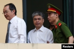 លោក Nguyen Xuan Son (រូប​កណ្តាល) អតីត​ប្រធាន​ក្រុមប្រឹក្សាភិបាល​របស់​ក្រុមហ៊ុន Petro Vietnam ត្រូវ​បាន​ប៉ូលិស​នាំ​ខ្លួន​ទៅ​តុលាការ​ដើម្បី​ស្តាប់​សាលក្រម​នៅ​ក្នុង​ក្រុង​ហាណូយ។